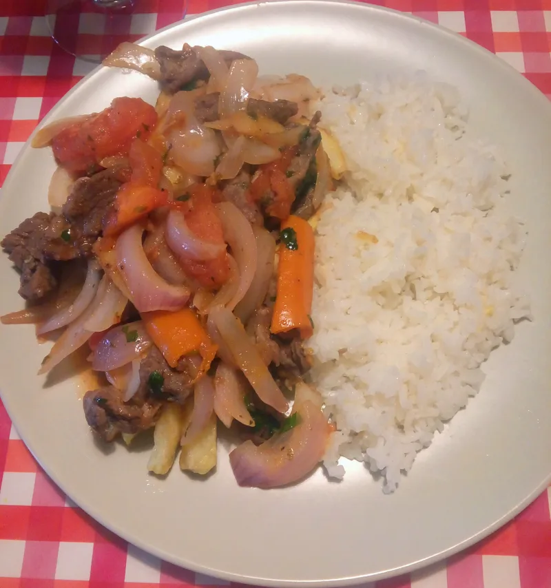 Lomo saltado peruano con papas fritas y arroz